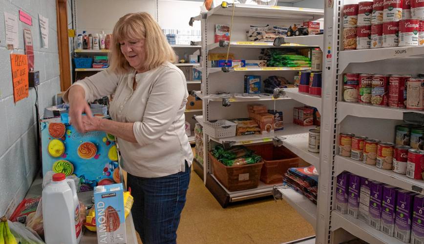Sue Lesniak, a volunteer with Neighbors Helping Neighbors food pantry in South Hadley, gathers items to fill orders to be delivered to those who are homebound. 