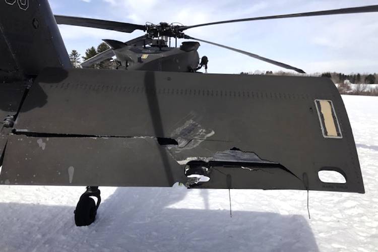 A damaged Black Hawk helicopter rests on the snow, March 13, 2019, in Worthington. A Massachusetts man wants the government to pay nearly $10 million after being badly injured in a crash with a Black Hawk helicopter. The lawsuit filed by Jeffrey Smith against the government follows a 2019 crash in which Smith's snowmobile collided with the helicopter that was parked on a trail at dusk.  