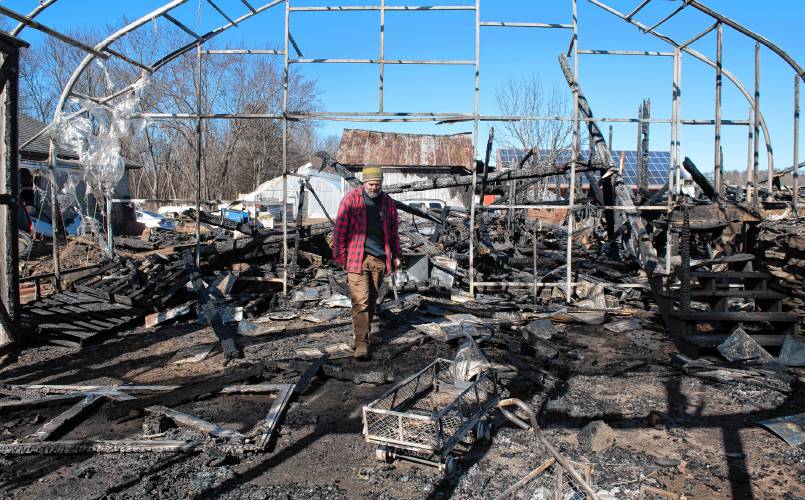 Ryan Voiland, co-owner of Red Fire Farm in Granby, walks through the greenhouse Feb. 20 and talks about the damage from a fire at the farm and what it will take to rebuild. The fire is just one example of hardships that area farmers have had to overcome in this and recent years. 