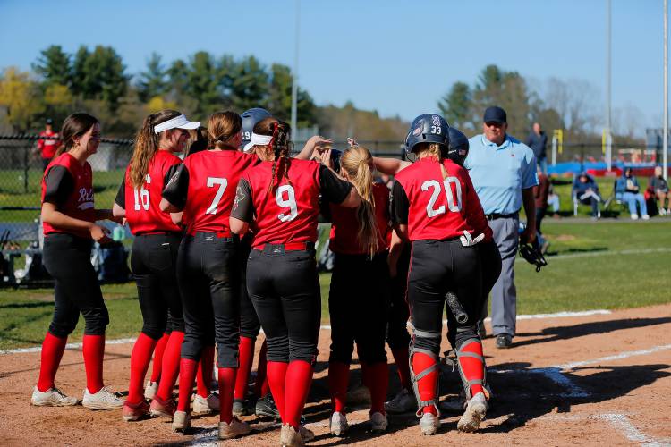 Hampshire Regional players surround CC Thayer (10) at home plate after hitting a 2-run home run against Easthampton in the bottom of the third inning Friday in Westhampton.