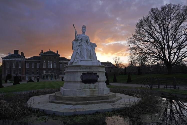 A statue of Queen Victoria stands in front of Kensington Palace during sunset in London, Friday, March 22, 2024. Kensington Palace contains the offices and London residences of The Prince and Princess of Wales. Kate, Princess of Wales, says she has cancer and is undergoing chemotherapy. (AP Photo/Alberto Pezzali)