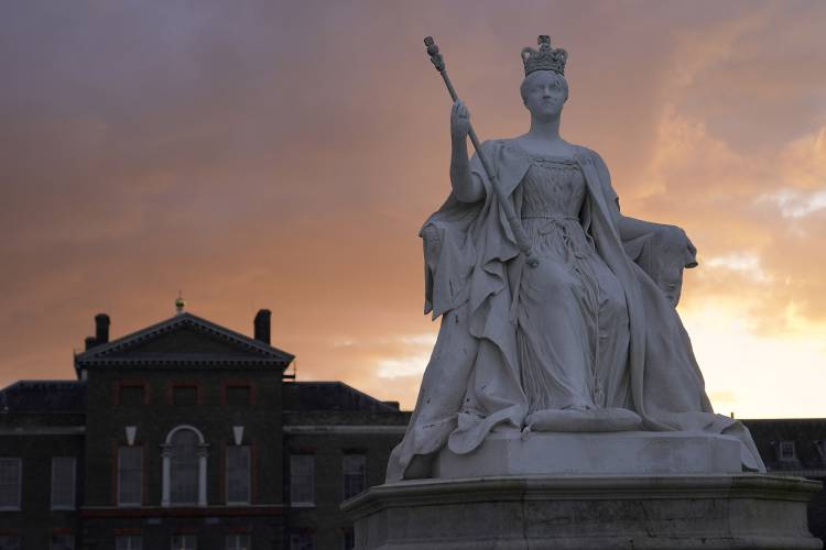 A statue of Queen Victoria stands in front of Kensington Palace during sunset in London, Friday, March 22, 2024. Kensington Palace contains the offices and London residences of The Prince and Princess of Wales. Kate, Princess of Wales, says she has cancer and is undergoing chemotherapy. (AP Photo/Alberto Pezzali)