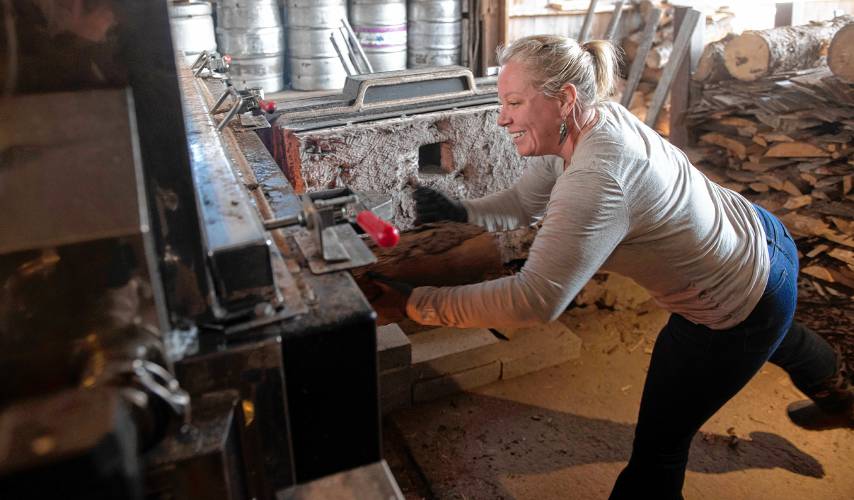 Amy Weber stokes the evaporator at Hickory Hill Farm in Worthington. “I love sugaring, I volunteer here so I can learn all I can,” Weber said.