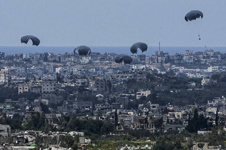 Parachutes drop supplies into the northern Gaza Strip, as seen from southern Israel on Sunday.
