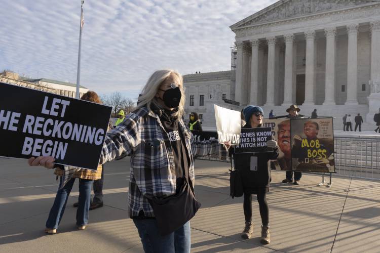 Myra Slotnick of Provincetown, Mass., holds banners in front of the U.S. Supreme Court, Thursday, Feb. 8, 2024, in Washington. (AP Photo/Manuel Balce Ceneta)