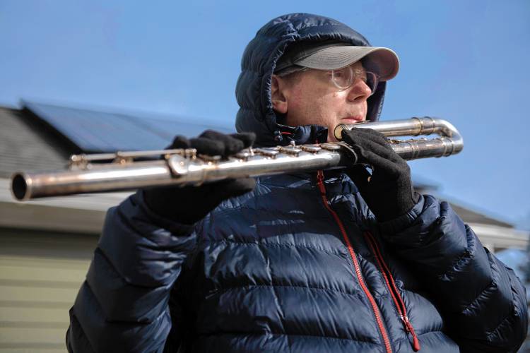David Bond, a professional musician, plays his bass flute outside in the cold weather on Monday morning in Northampton’s Village Hill neighborhood. “It’s a morning meditation,” Bond explained of his daily routine. “It’s like exercising my lungs but by playing an  instrument.”