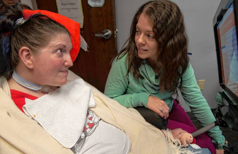 Megan Golightly, a speech-language pathologist at Strive Clinic in Holyoke, watches as Mel Hearne responds yes by raising her eyebrows to a question Golightly asked her. Hearne is learning how to use an Eye Gaze Trilogy which allows Hearne to communicate by using her eyes to select symbols and letters.