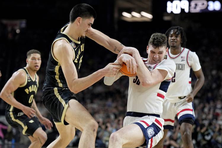 Purdue center Zach Edey, left, and UConn center Donovan Clingan battle for the ball during the first half of the NCAA college Final Four championship basketball game, Monday, April 8, 2024, in Glendale, Ariz. (AP Photo/Brynn Anderson)