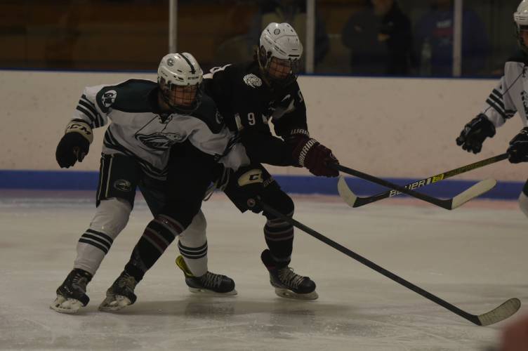 Amherst’s Cooper Beckwith (9), right, battles for puck possession with Greenfield’s Jack Laurie during action earlier this season. Beckwith was selected as the Daily Hampshire Gazette’s  Ice Hockey Player of the Year.