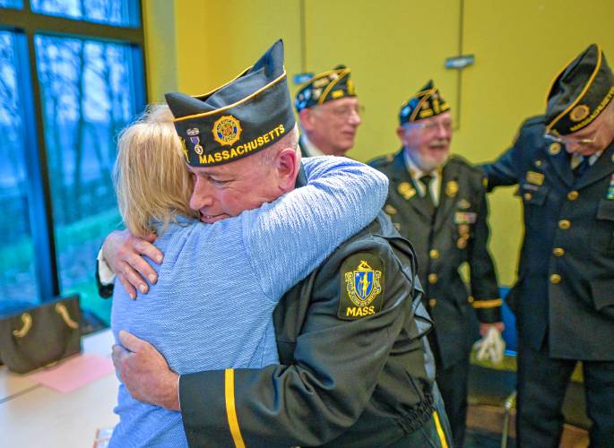 South Hadley native Susan Opalenik, left, a resident of Springfield, receives a hug from Brian Willette, commander of South Hadley American Legion Post 260, during National Vietnam War Veterans Day Commemoration at the South Hadley Public Library on Thursday. Opalenik attended the ceremony on behalf of her cousin, Robert J. Sowinski, who was killed during the Vietnam War in 1968.