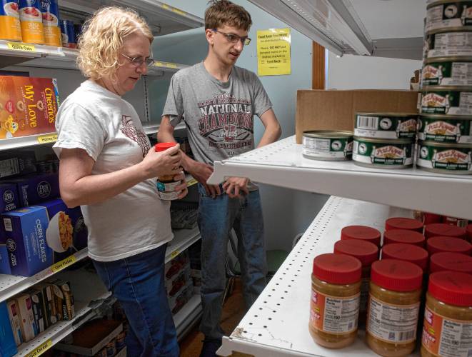 Sarah Smith and Fletcher Smith, volunteers with Neighbors Helping Neighbors food pantry in South Hadley, gather items to fill orders to be delivered to those who are homebound. 