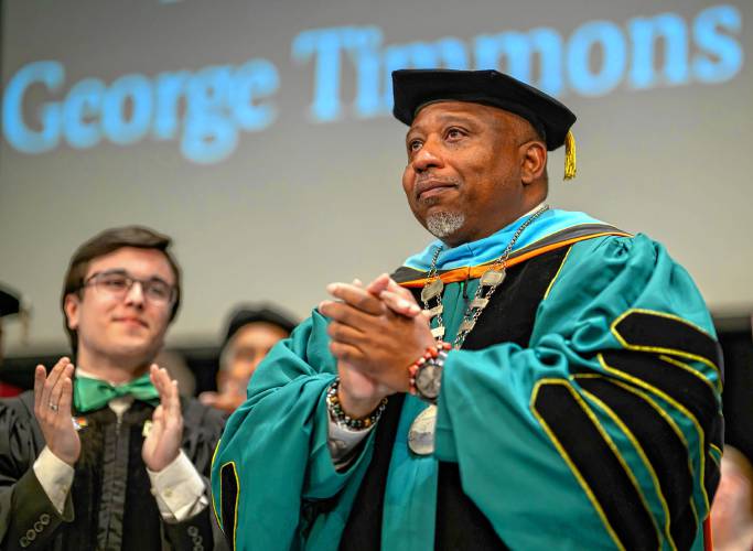 Holyoke Community College student trustee Barney Garcia, left, applauds as George Timmons is installed as the fifth president of Holyoke Community College during an inauguration ceremony in Holyoke on Friday, April 19, 2024.