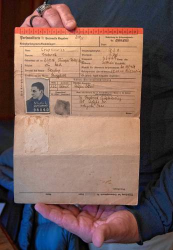 Mike Boyington, grandson of Frederick Czupkiewicz, holds the original papers kept by the Germans as a record of the time Czupkiewicz spent in POW camps.
