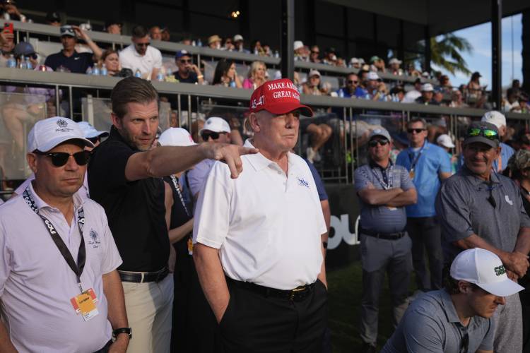 Republican presidential candidate former President Donald Trump, center, and son Eric Trump, second left, watch play on the 18th hole green during the final round of LIV Golf Miami, at Trump National Doral Golf Club, Sunday, April 7, 2024, in Doral, Fla. (AP Photo/Rebecca Blackwell)