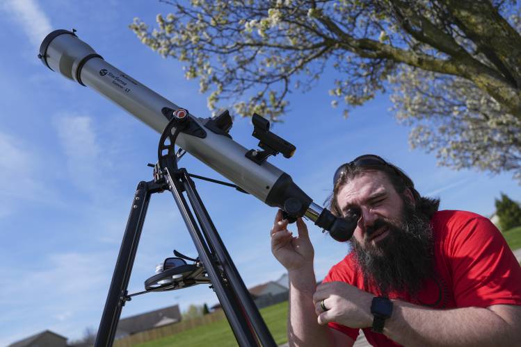 Kenny Riehl, of Solon, Iowa, adjusts a telescope while looking at the sun before a total solar eclipse, Monday, April 8, 2024, in Trenton, Ohio. (AP Photo/Joshua A. Bickel)
