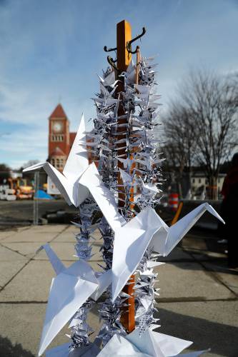Local artist JuPong Lin displays strands of origami peace birds Friday afternoon in downtown Amherst to raise awareness of the upcoming Town Council vote on the Gaza Ceasefire Resolution.