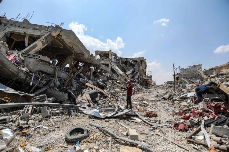 People inspect damage and remove items from their homes following Israeli airstrikes on Tuesday, April 9, 2024, in Khan Yunis, Gaza.