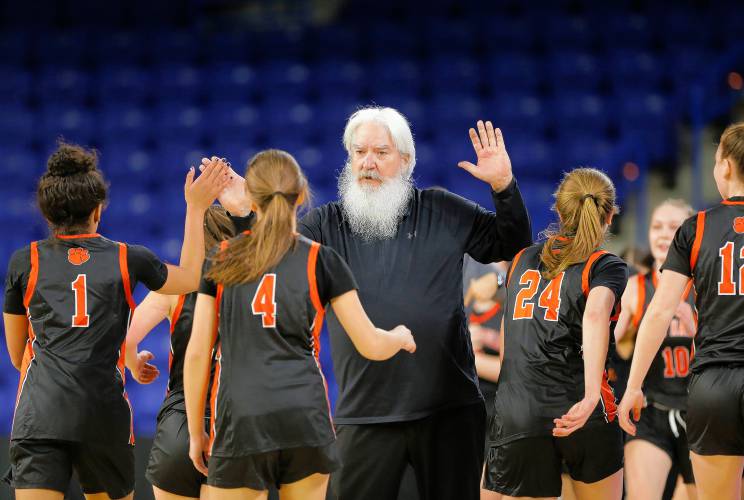 South Hadley head coach Paul Dubuc high fives his players in the first quarter against Cathedral during the MIAA Div. 4 girls basketball state final Sunday afternoon at the Tsongas Center in Lowell.