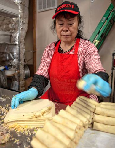 Maria Zhao, an employee at the Little Wall, makes egg rolls at the restaurant on Main Street in Florence. 