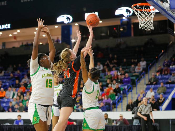 South Hadley’s Kate Phillips (24) hits a shot over Cathedral defenders Leilani Benson (15) and Hijjah Allen- Paisley (2) in the fourth quarter of the MIAA Div. 4 girls basketball state final Sunday afternoon at the Tsongas Center in Lowell.