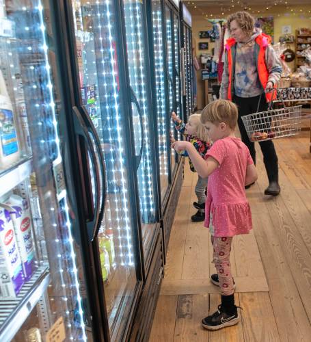 Abel Reagan, 4, Etta Reagan, 2, and their mother Samantha Spisiak shop at the Leverett Village Co-Op for after noon snacks Tuesday afternoon, December 19, 2023.
