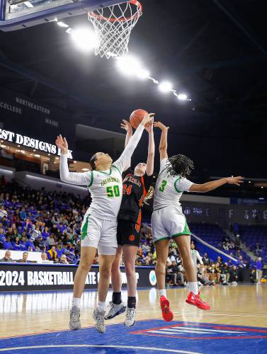 South Hadley’s Kate Phillips (24) drives to the hoop between Cathedral defenders Sky DaCosta (50) and Jasmine Day-Cox (3) in the fourth quarter of the MIAA Div. 4 girls basketball state final Sunday afternoon at the Tsongas Center in Lowell.