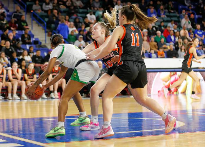 South Hadley’s Ava Asselin (10) and CC Gurek (11) defend against Cathedral’s Hijjah Allen- Paisley (2) in the third quarter of the MIAA Div. 4 girls basketball state final Sunday afternoon at the Tsongas Center in Lowell.