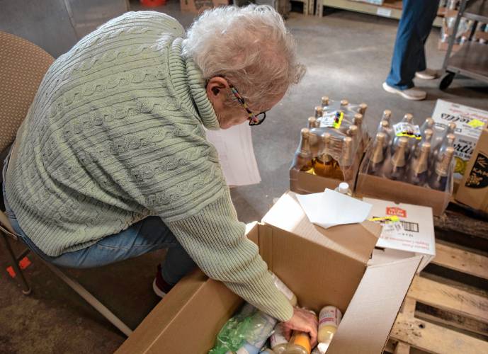 Donna Zimmerman , a volunteer at the Leverett Village Co-Op, checks a recent delivery.