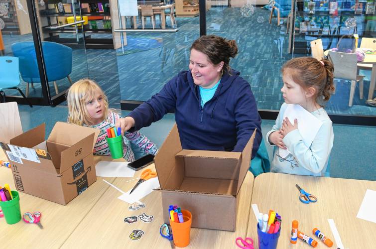 Greenfield resident Kayla Stover and her children Harper, 4, and Lilah, 6, craft eclipse-viewing boxes during a workshop at the Greenfield Public Library on Wednesday.