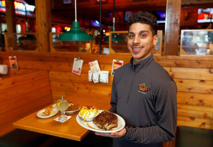 Training Coordinator and Line Cook Joevonnee Rodriguez with the bone-in ribeye steak and loaded mashed potatoes Tuesday afternoon at Texas Roadhouse in Hadley.