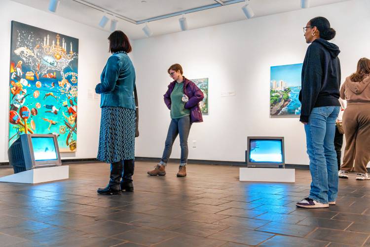 Visitors to “Trópico es Político” at the Mead Art Museum view some of the artwork, which includes video, painting, photography and varied installations.