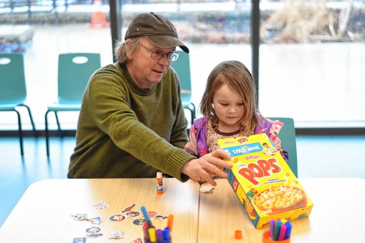 Greenfield resident Horace Taft and his granddaughter Helen Taft-Ferguson, 4, craft eclipse-viewing boxes during a workshop at the Greenfield Public Library on Wednesday.