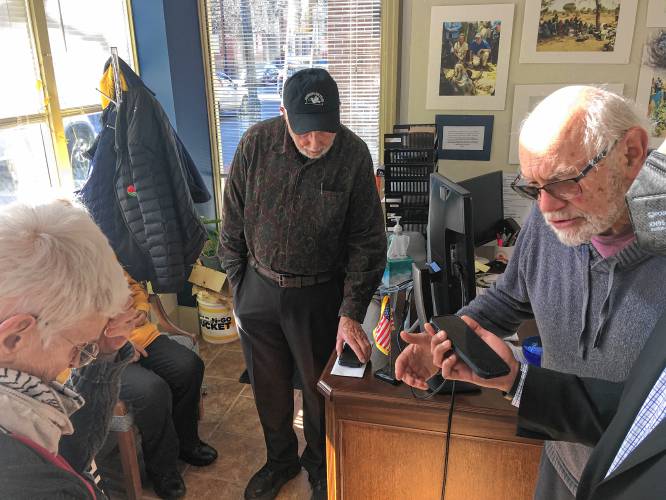 Peter Kakos, right, talks to U.S. Rep. Jim McGovern in McGovern’s Northampton office Tuesday as Paki Wieland, left, and Nick Mottern listen. McGovern’s regional manager, Koby Gardner-Levine, holds the phone.  