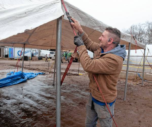 Marco Basile, owner of Rent-A-Tent out of East Longmeadow, puts up a tent he donated to Red Fire Farm.