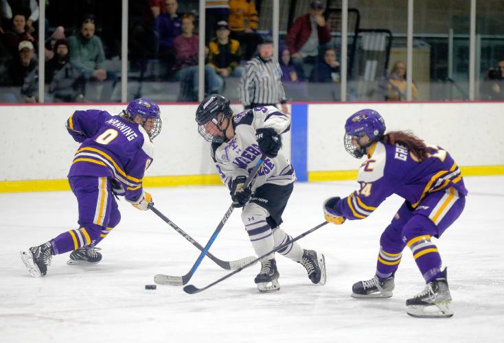 Amherst College’s Maeve Reynolds (9) maneuvers the puck between Elmira College’s Katie Manning (9) and Sophie Gregory (24) in the third period of the NCAA quarterfinals Saturday afternoon at Orr Rink.
