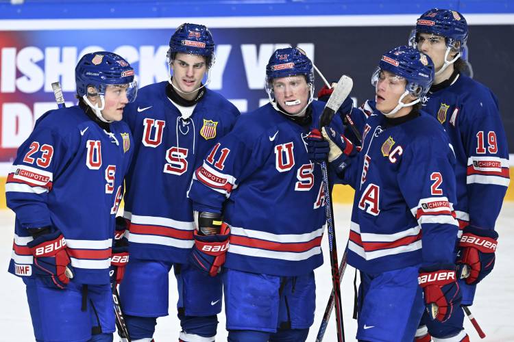 USA's Oliver Moore, center, celebrates scoring during the IIHF World Junior Championship ice hockey quarterfinal match between USA and Latvia at Frolundaborg in Gothenburg, Sweden, Tuesday Jan. 2, 2024. (Bjorn Larsson Rosvall/TT via AP)