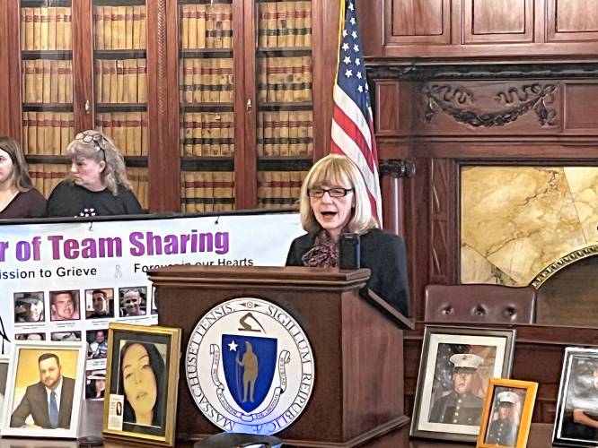 Surrounded by pictures of people who have died of overdoses, Maryanne Frangules, executive director of the Massachusetts Organization for Addiction Recovery, speaks at the State House on Thursday during a rally to support state legislation for creating overdose prevention centers.