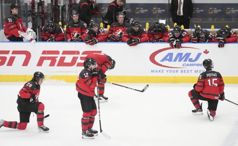 Canada players, from left, Conor Geekie, Fraser Minten and Matthew Poitras react following their loss to Czechia in a quarterfinal match at the IIHF World Junior Hockey Championship in Gothenburg, Sweden, Tuesday, Jan. 2, 2024. Christinne Muschi/The Canadian Press via AP)
