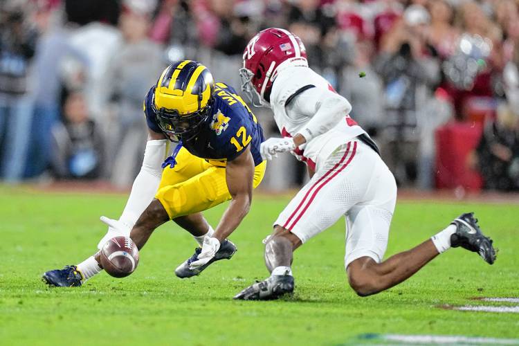 Michigan defensive back Josh Wallace (12) recovers a fumble by Alabama quarterback Jalen Milroe (4) during the second half in the Rose Bowl CFP NCAA semifinal game on Jan. 1 in Pasadena, Calif.