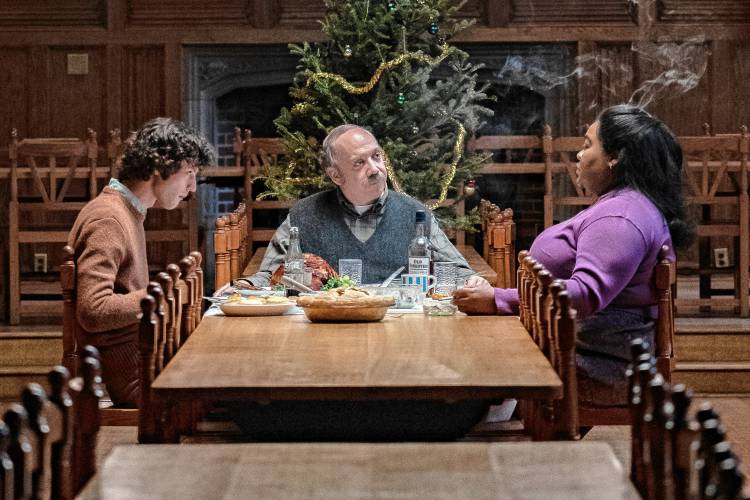 Dominic Sessa, Paul Giamatti, and Da’Vine Joy Randolph share Christmas dinner in a scene from “The Holdovers.” 
