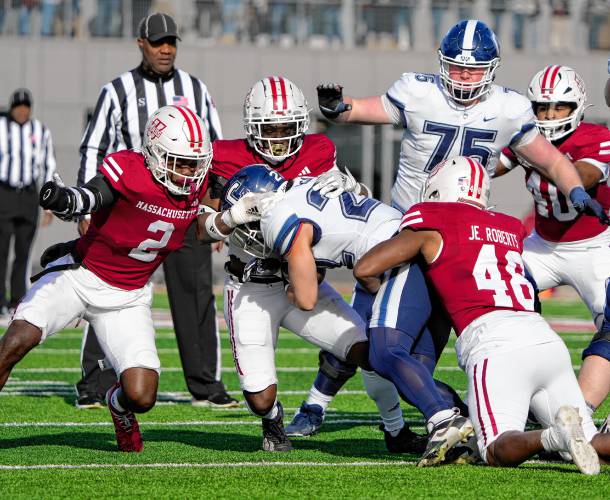 UMass defenders Tyler Rudolph (2) and Jerry Roberts Jr. (48) help make a tackle on UConn running back Victor Rosa (22) during the Minutemen’s 31-18 loss on Saturday at McGuirk Alumni Stadium in Amherst.