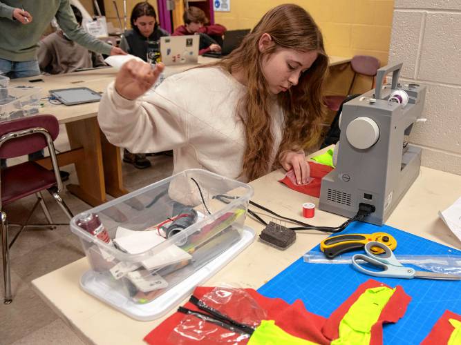 Libby Smith, an Amherst High School student, works on creating a waterproof pocket for the chip that is part of the InvenTeam’s project this year called SARAH, Search And Rescue Assistant Hardware. The project will transmit vital signs of search and rescue personnel while they are on a mission.