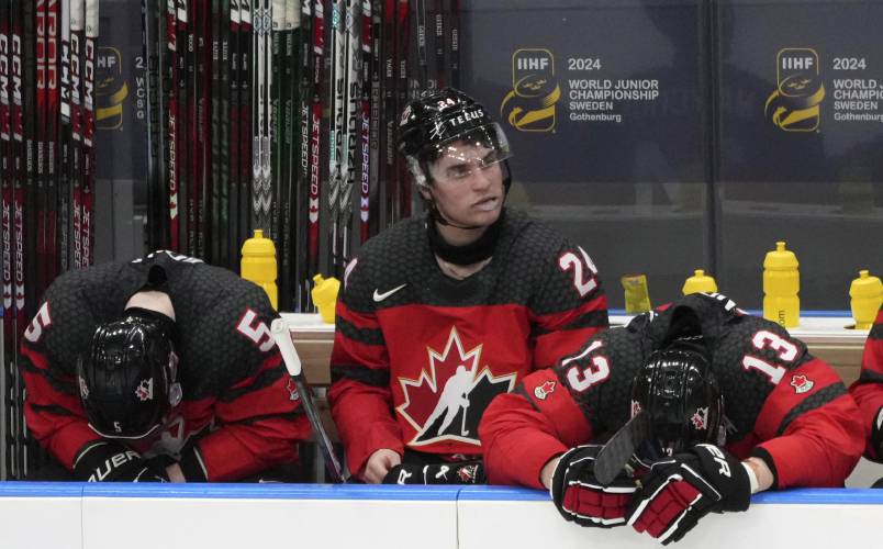 Canada players, from left, Oliver Bonk (5), Denton Mateychuk (24) and Maveric Lamoureux (13) react following their loss to Czechia in a quarterfinal match at the IIHF World Junior Hockey Championship in Gothenburg, Sweden, Tuesday, Jan. 2, 2024. (Christinne Muschi/The Canadian Press via AP)