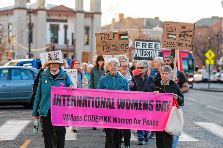 Susan Lantz, from left, Sheila Delson and Ellen Graves lead dozens of community members on a march down Main Street after rallying at City Hall in Northampton on Friday as part of CODEPINK’s 19th annual celebration of International Women’s Day with the theme, “We mourn, we resist, we organize: Peace & Justice for the Palestinians and all peoples.”
