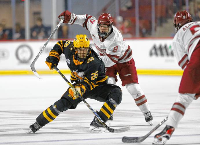 UMass left wing Jack Musa (9) and defender Linden Alger (5) work to stop the attack from AIC left wing Alexander Malinowski (25) earlier this season at the Mullins Center in Amherst.