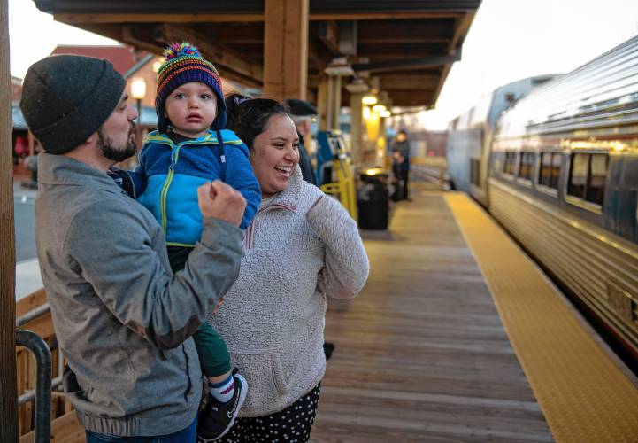 Cam Brown holds his son, Dominic Brown, with his wife and Dominic’s mother, Ximenca Cruz de Brown, as they wait for Cruz de Brown’s parents to arrive by train at the Northampton  station.