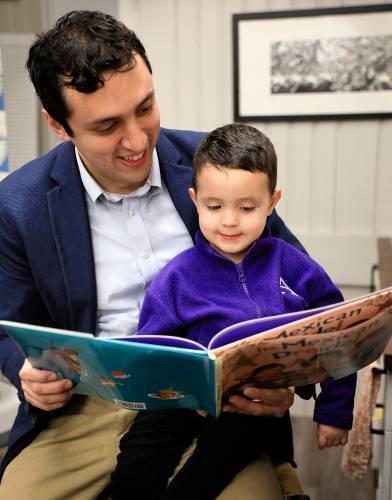 Amherst College professor Lloyd Barba reads “The Mexican Dreidel” to his 2-year-old son, Daniel, at Restless Books. The story, by Linda Elovitz Marshall and Ilan Stavans, has a main character, Danielito, who’s based on Daniel.