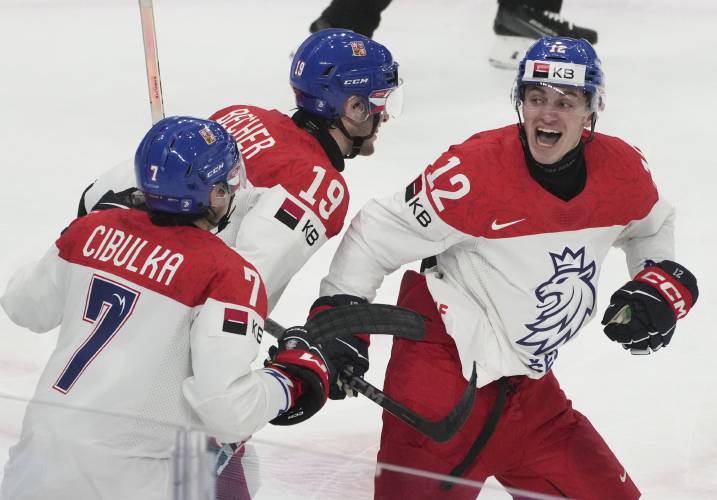 Czechia's Dominik Rymon (12), Ondrej Becher (19) and Tomas Cibulka (7) celebrate the game-winning goal against Canada by teammate Czechia's Jakub Stancl (not shown) during the third period of a quarterfinal match at the IIHF World Junior Hockey Championship in Gothenburg, Sweden, Tuesday, Jan. 2, 2024. Christinne Muschi/The Canadian Press via AP)