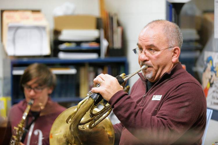 Bombyx Brass Collective founder Ira Brezinsky plays through music with the french horn section while visiting the South Hadley High School band class Tuesday morning at the high school.