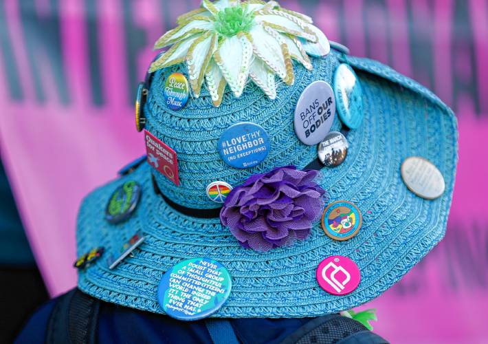 Buttons adorn the hat of an activist attending CODEPINK’s 19th annual celebration of International Women’s Day rally at City Hall in Northampton on Friday with the theme, “We mourn, we resist, we organize: Peace & Justice for the Palestinians and all peoples.”
